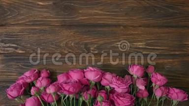 木制背景，粉红色的花和复制空间的文字，花店铺束玫瑰在木板上